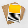 a card with a yellow square and black horizontal stripes, placed on top of a brown envelope.