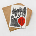 a card with a cityscape illustration and a red hot air balloon, along with the word "BRISTOL" written on it.
