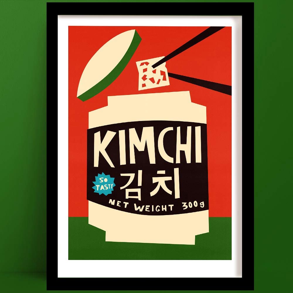 Kimchi print featuring a cream jar with black label, bold chopsticks, and graphic Korean text, framed on green wall.