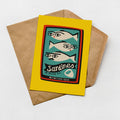 A yellow envelope with a printed label featuring a graphic of three fish and text, along with a small icon of a fish and a fish-shaped label.
