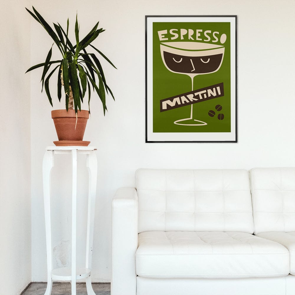 Espresso Martini artwork framed above a white sofa in a bright, modern space with a tall indoor plant for contrast.