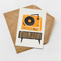 an illustration of a vintage record player with a brown envelope underneath it.