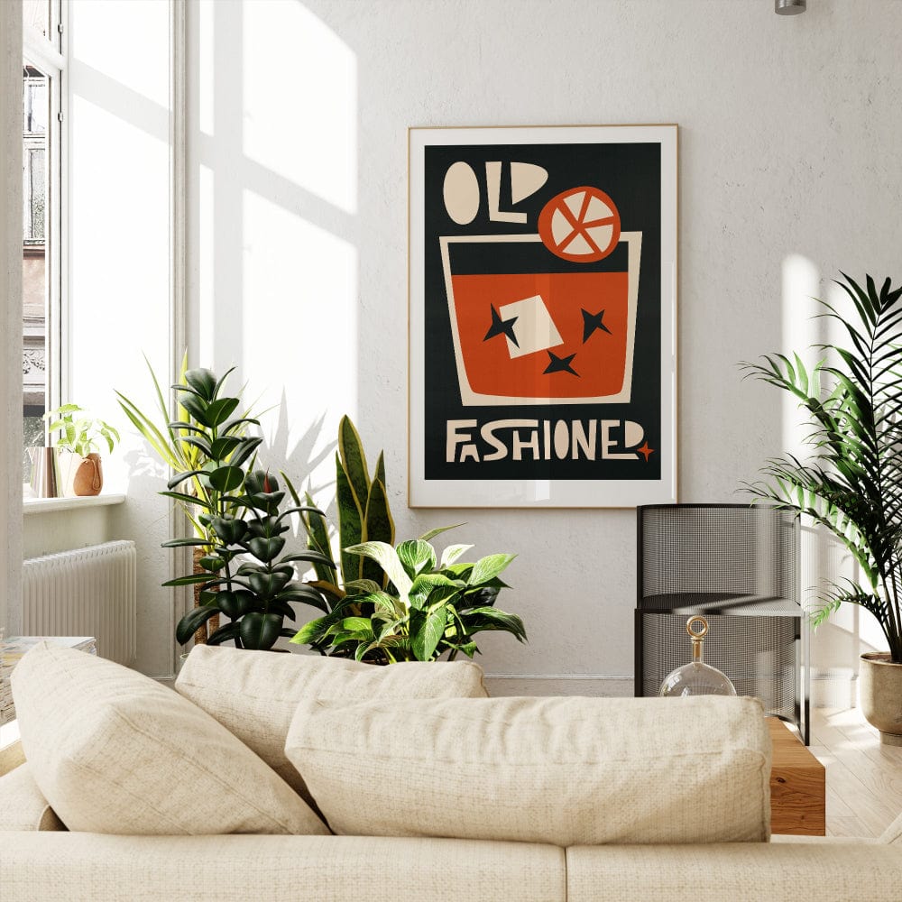 Old Fashioned print hanging above a white sofa in a bright room filled with natural light and greenery.