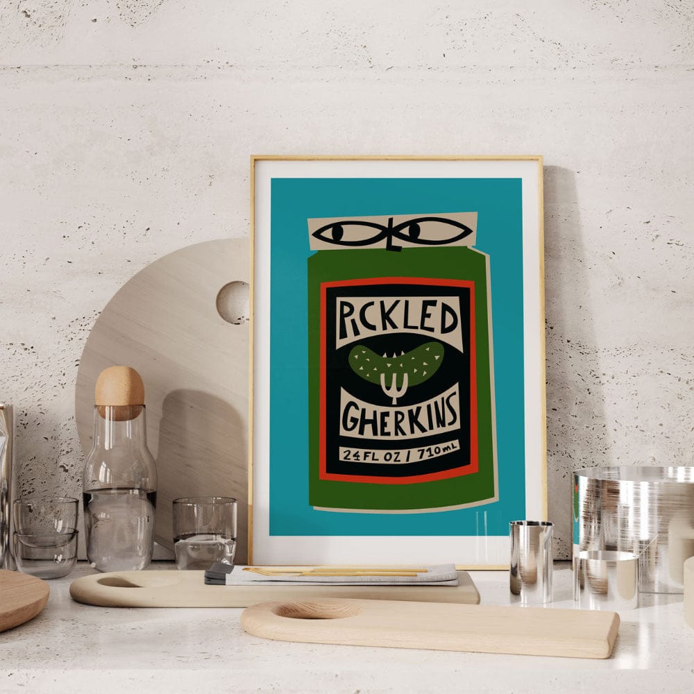 Pickled Gherkins print framed on a stone-textured wall shelf with barware and utensils.