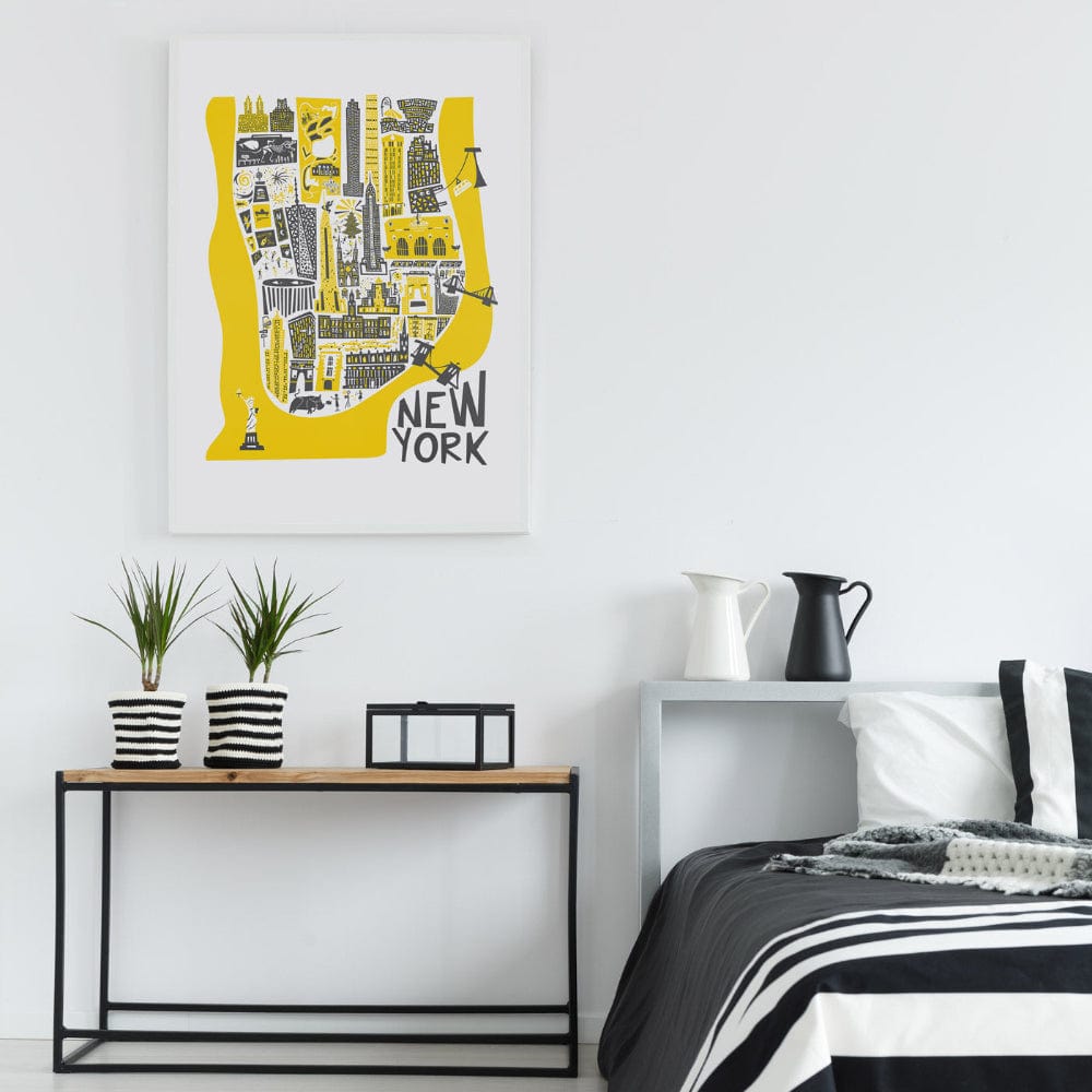 Framed yellow New York map print displayed above a bed in a minimalist room, adding a pop of colour and urban flair to the monochrome decor.