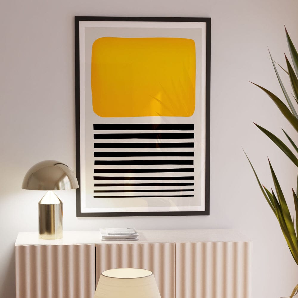 Framed yellow abstract artwork in softly lit modern room, styled with indoor plant and lamp