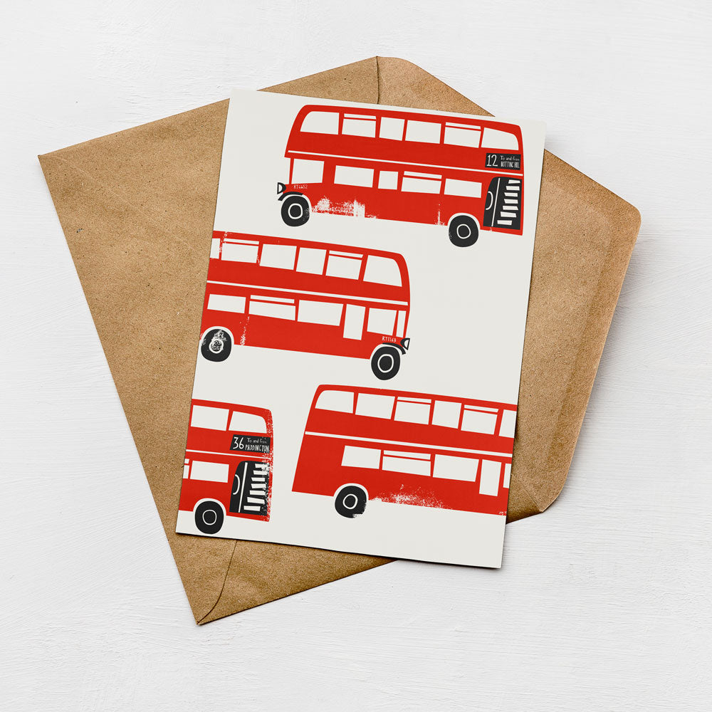 a brown envelope with a white card inside, which displays a pattern of red double-decker buses.