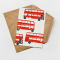 a brown envelope with a white card inside, which displays a pattern of red double-decker buses.