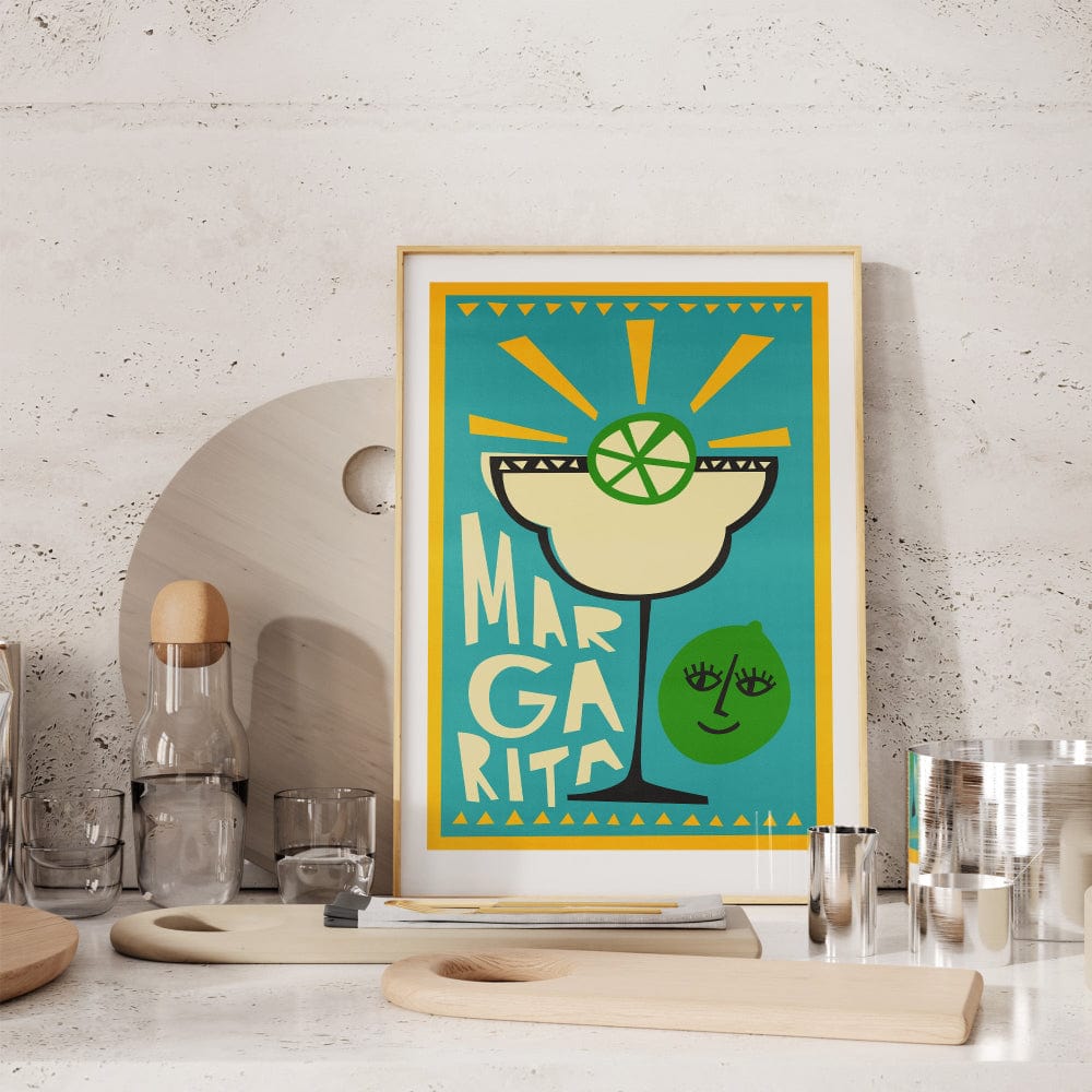 Margarita print propped on a kitchen shelf near glasses and ceramics, adding a playful splash of teal and yellow.