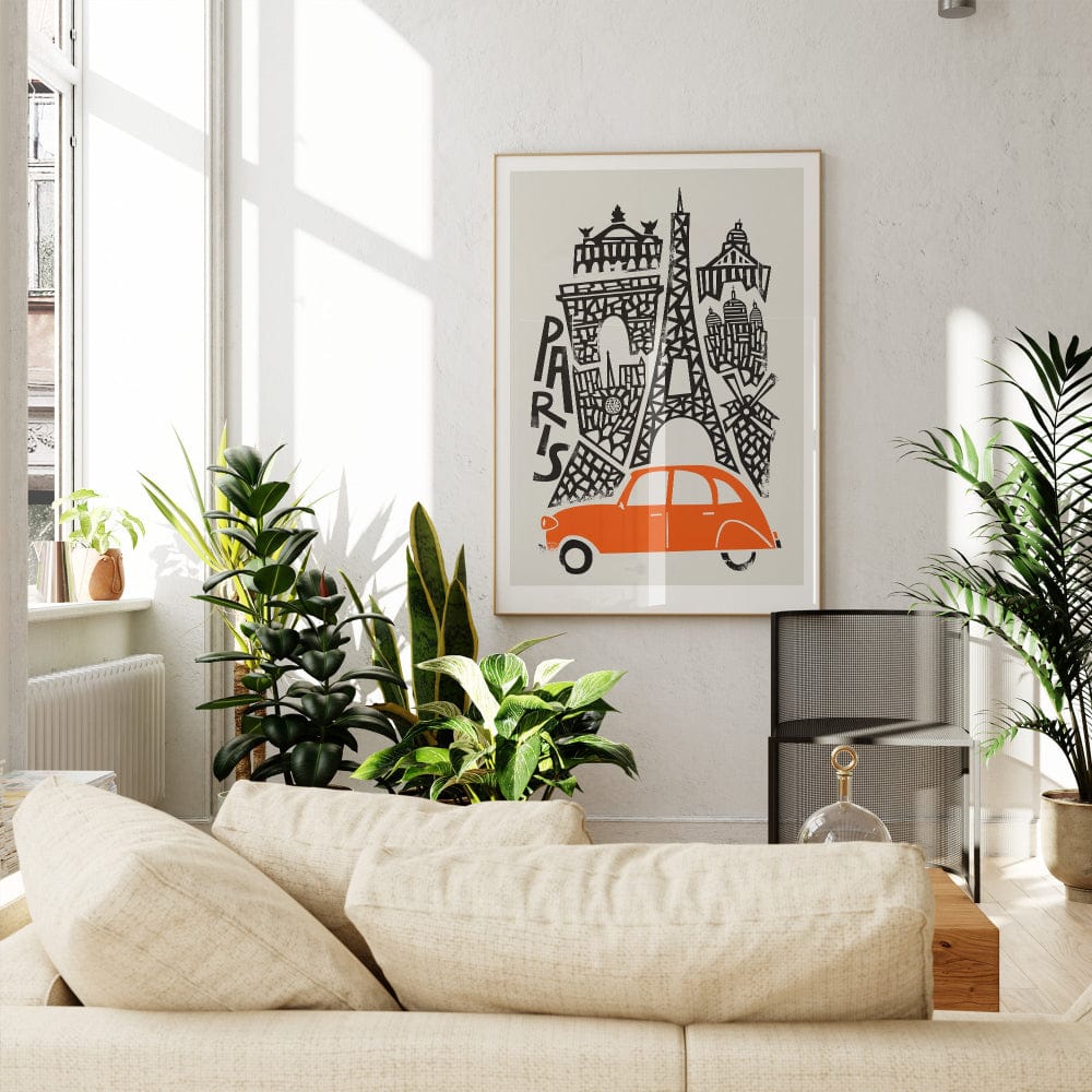 The Paris print styled in a chic, modern room with warm wood tones and greenery, the vintage car adding a pop of colour against the monochrome buildings.