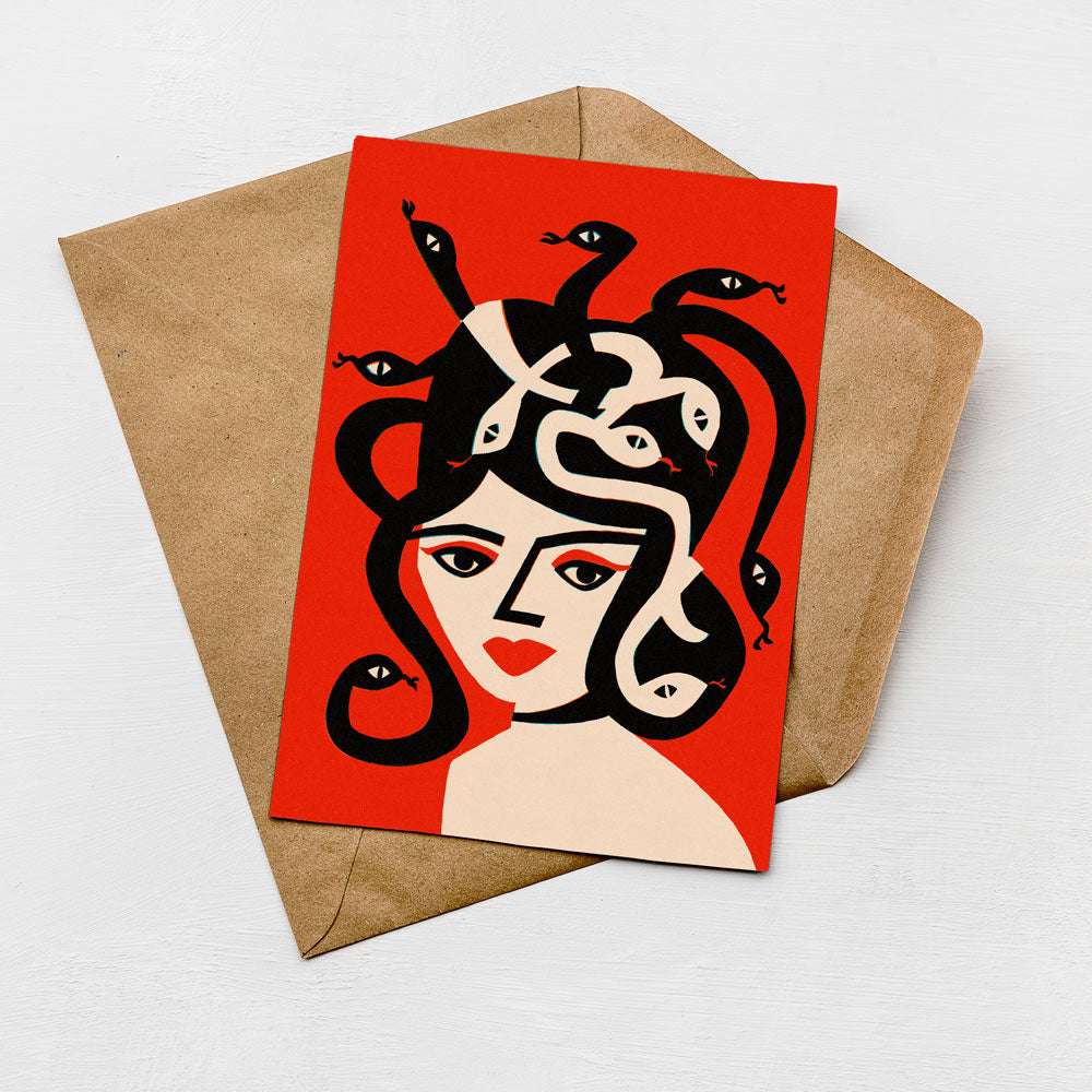 a card with a stylized illustration of a woman's face on a red background, surrounded by multiple snakes.