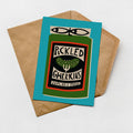 A card with a graphic design featuring a can of pickled gherkins, placed on top of a brown envelope against a white background.