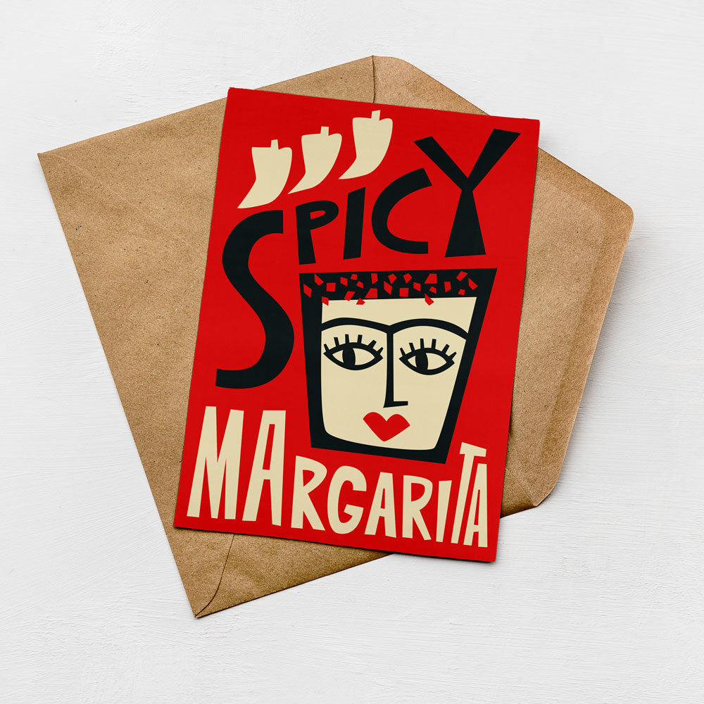 A red card with a stylized face and the text "SPICY MARGARITA" printed on it, placed on a brown envelope against a white background.