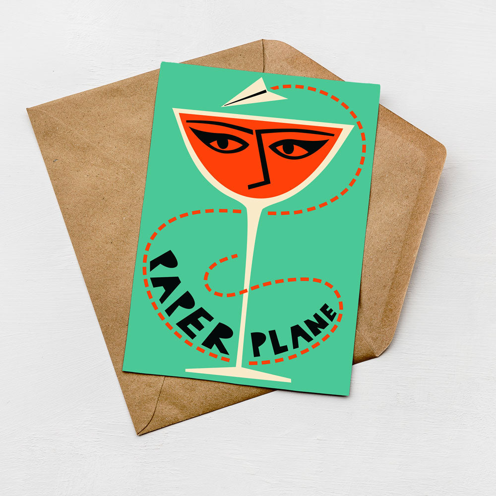 A card with a stylized illustration of a paper airplane on a teal background, accompanied by the text "PAPER PLANE" in bold black letters.