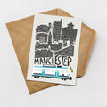 a card with a stylized illustration of a city skyline, including a train, and the word "MANCHESTER" written on it.