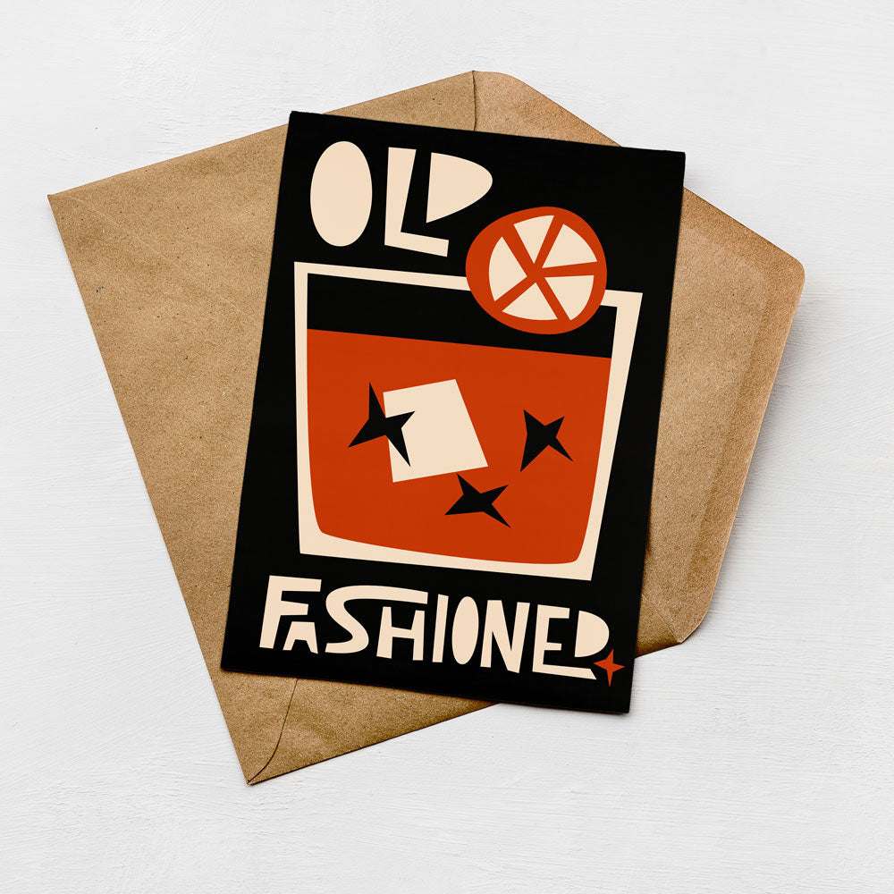 a card with a stylized design and text, placed on a brown envelope against a white background.