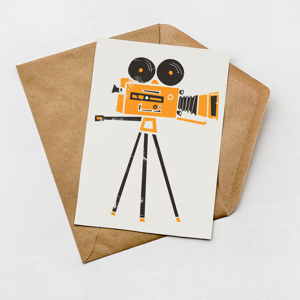 a card with an illustration of a camera on it, placed on top of an envelope.