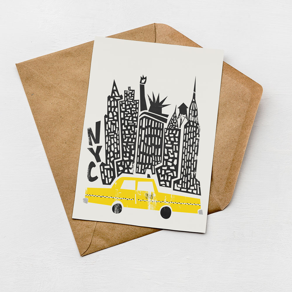 A greeting card featuring a stylized illustration of a yellow taxi in front of a city skyline, with the text "NYC" prominently displayed.