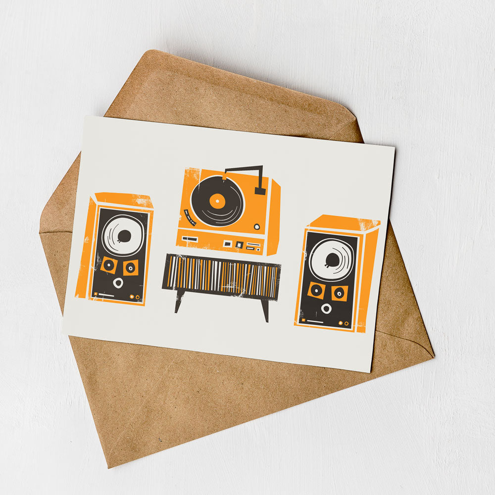 A greeting card with an illustration of a record player and two speakers, along with a brown envelope.