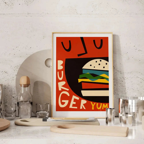 The Burger Yum print displayed in a minimalist kitchen setting, adding a bold splash of red and personality to the space.