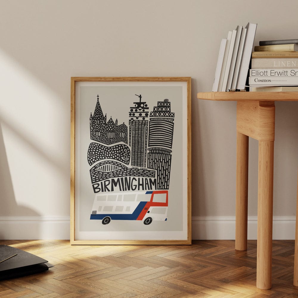 The Birmingham city print casually leaning against a neutral wall near a wooden desk, styled in a relaxed and modern interior.