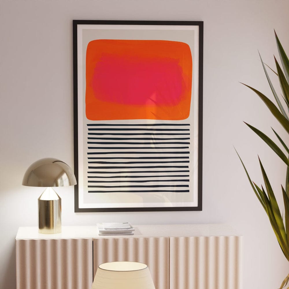 Framed abstract sunset ripples print hanging above a fluted sideboard, softly lit in a neutral room.