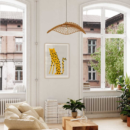 Framed cheetah print hanging in a bright living space near a large window, bringing personality and energy to the calm, natural interior.