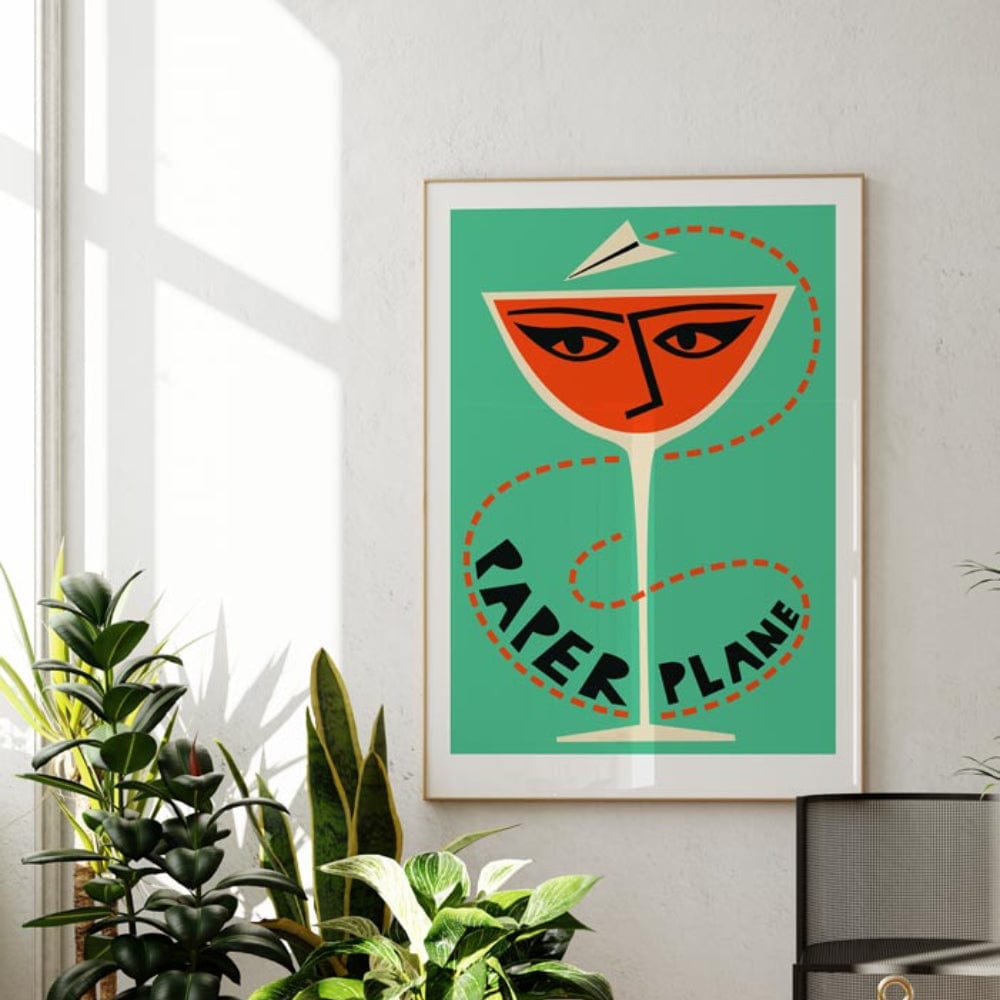 The Paper Plane artwork shown framed in a bright modern room, its playful colour palette and minimal lines adding an energetic, mid-century pop to the decor.