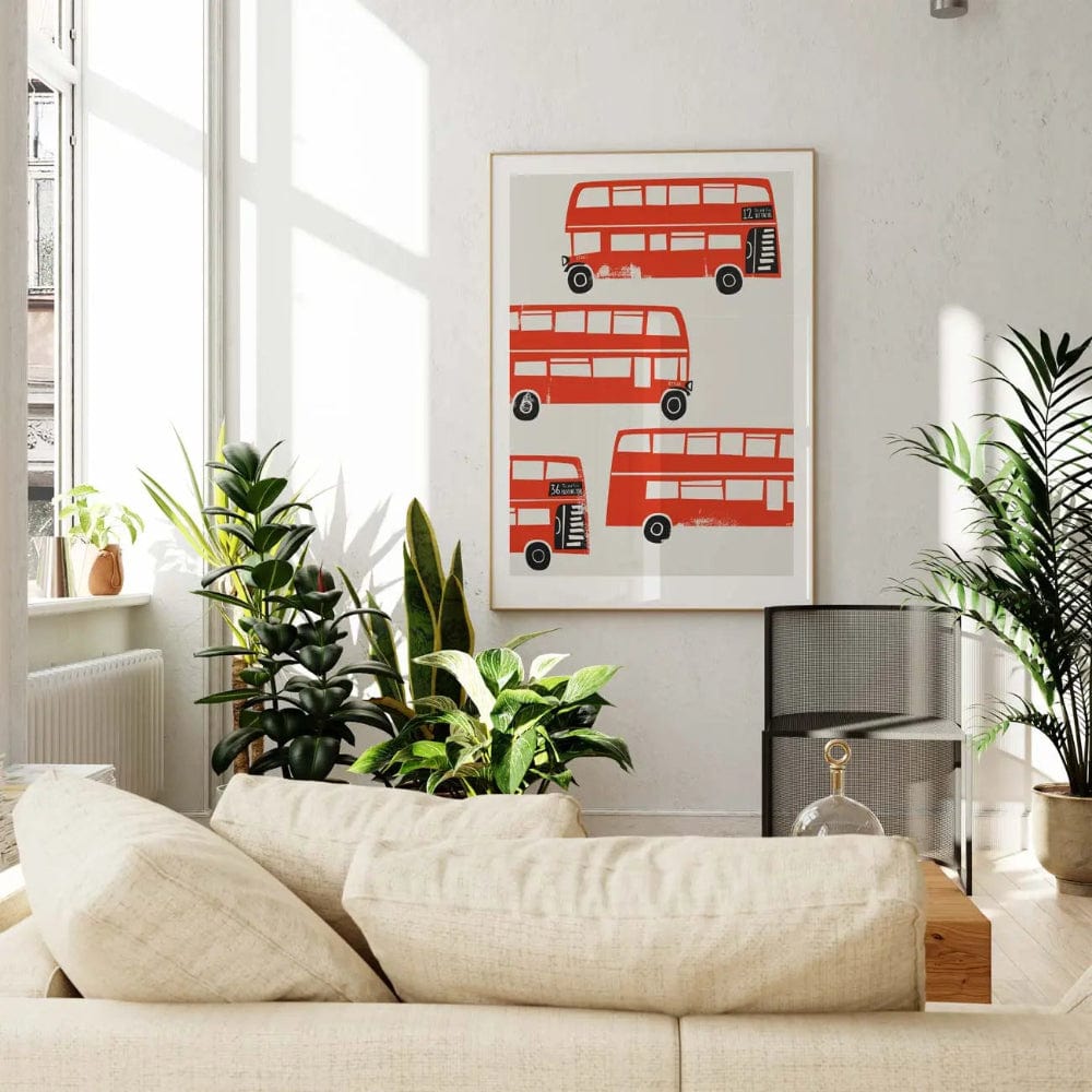 London bus wall art styled in a bright, leafy lounge space, complementing the neutral palette with its bold red accents and joyful mid-century layout.