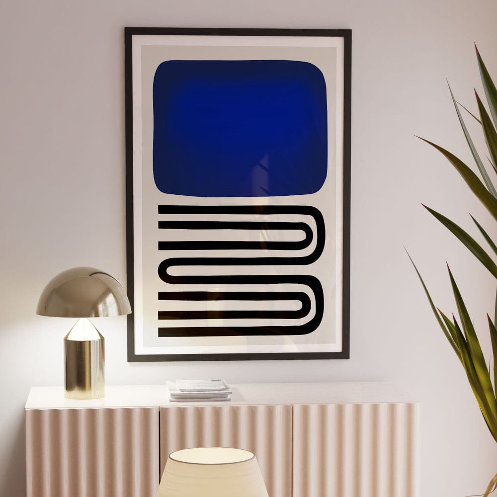 Blue abstract art print framed above radiator cabinet, styled with lamp and tall green plant