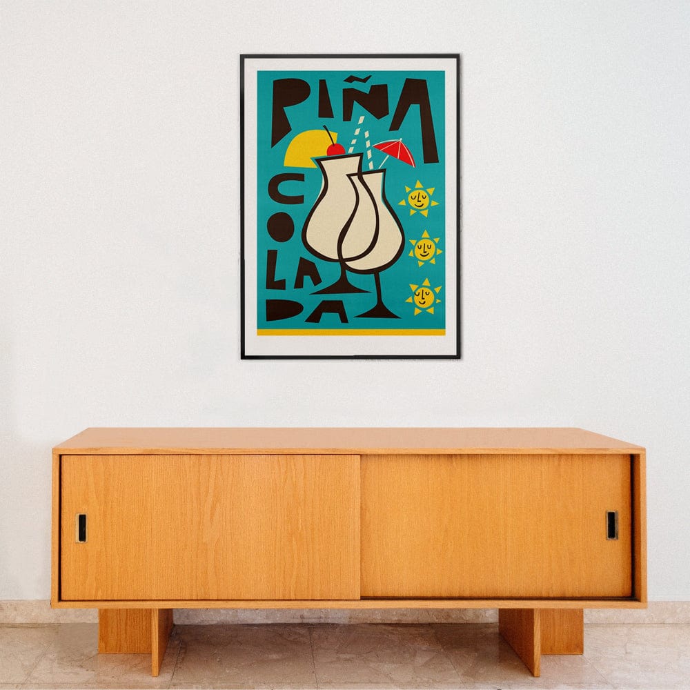 Retro-style piña colada wall art adding warmth and whimsy to a clean interior with light wood furniture.