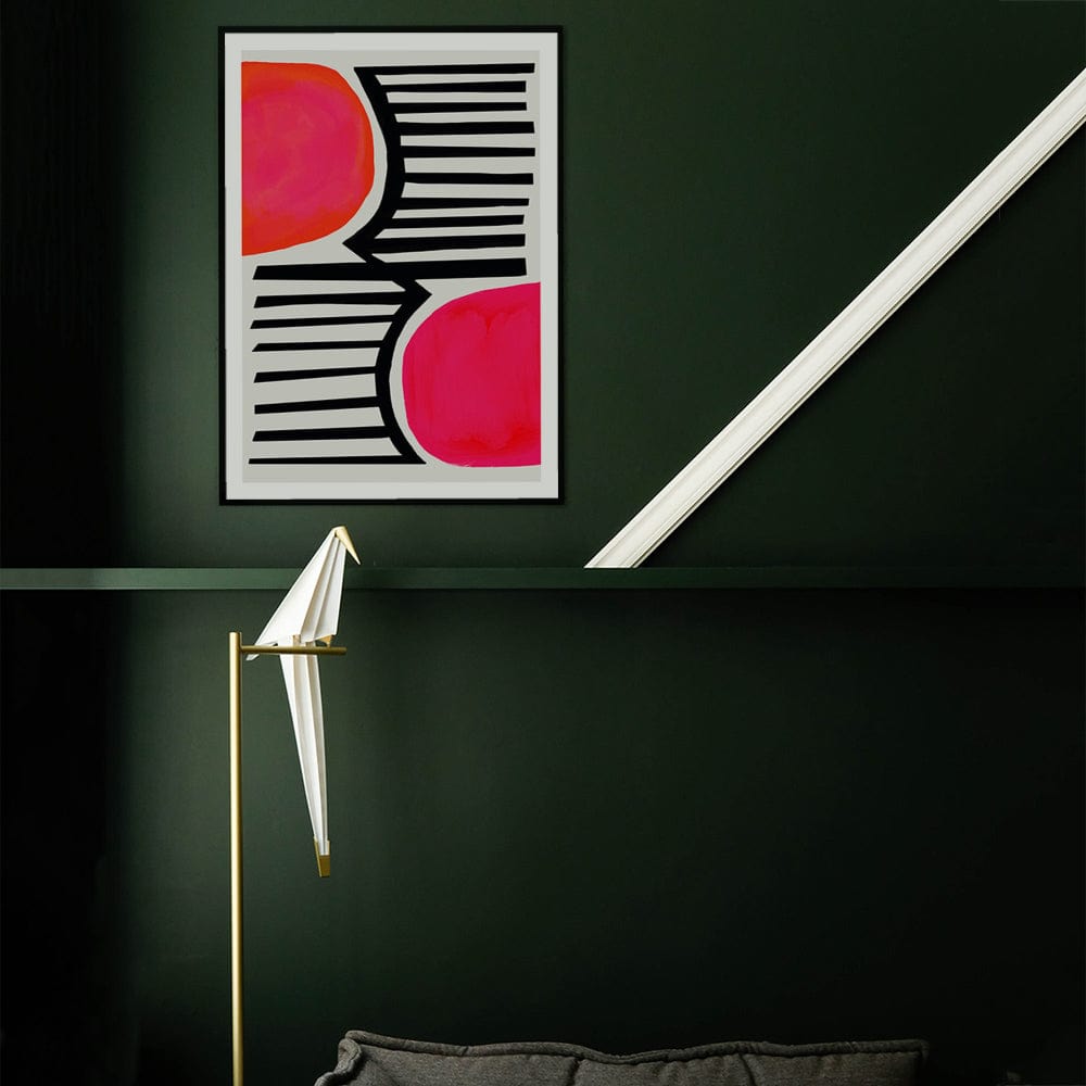 High-contrast abstract print with vibrant pink forms and linear black elements styled against a dark green wall.