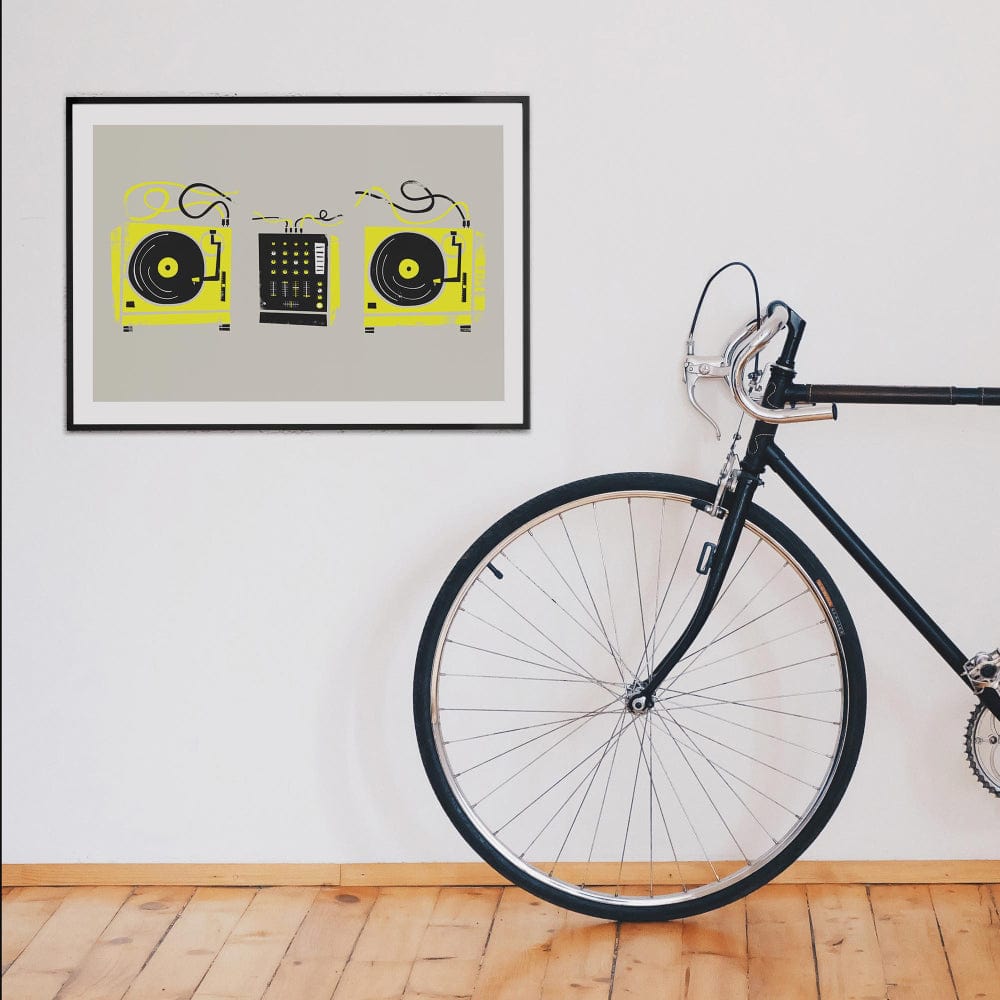 DJ decks art print hanging on a white wall next to a black bicycle in a stylish interior setting