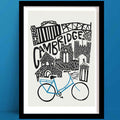 Our Cambridge print, A monochrome cityscape illustration, features iconic university buildings, turrets, and the Mathematical Bridge, with a bright blue bicycle below.
