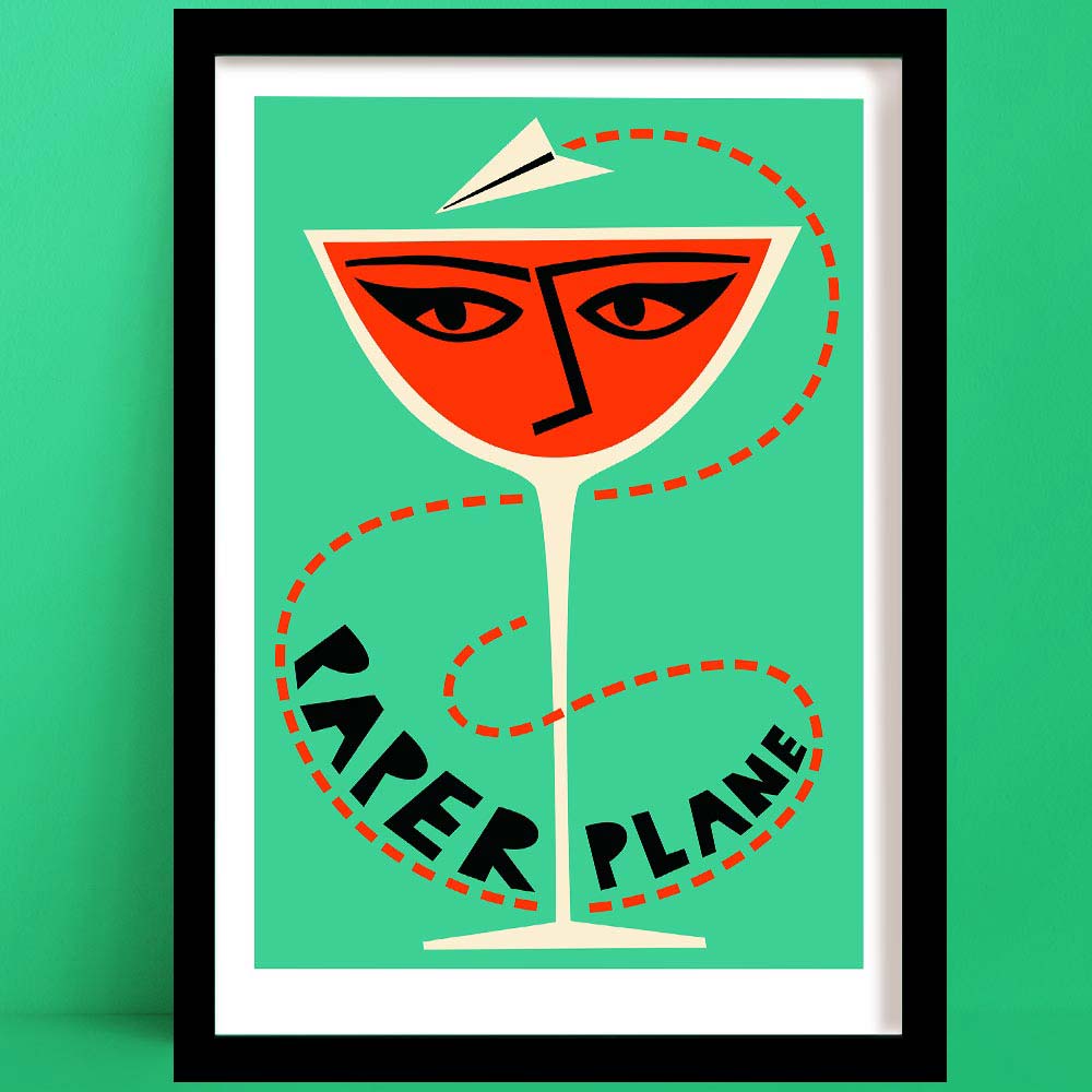 A bold paper plane cocktail print featuring a vivid orange drink in a coupe glass, illustrated with a stylised face and topped with a flying paper plane, all set against a mint green backdrop.