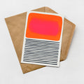 a card with a bold, abstract design on it, placed on top of a brown envelope.