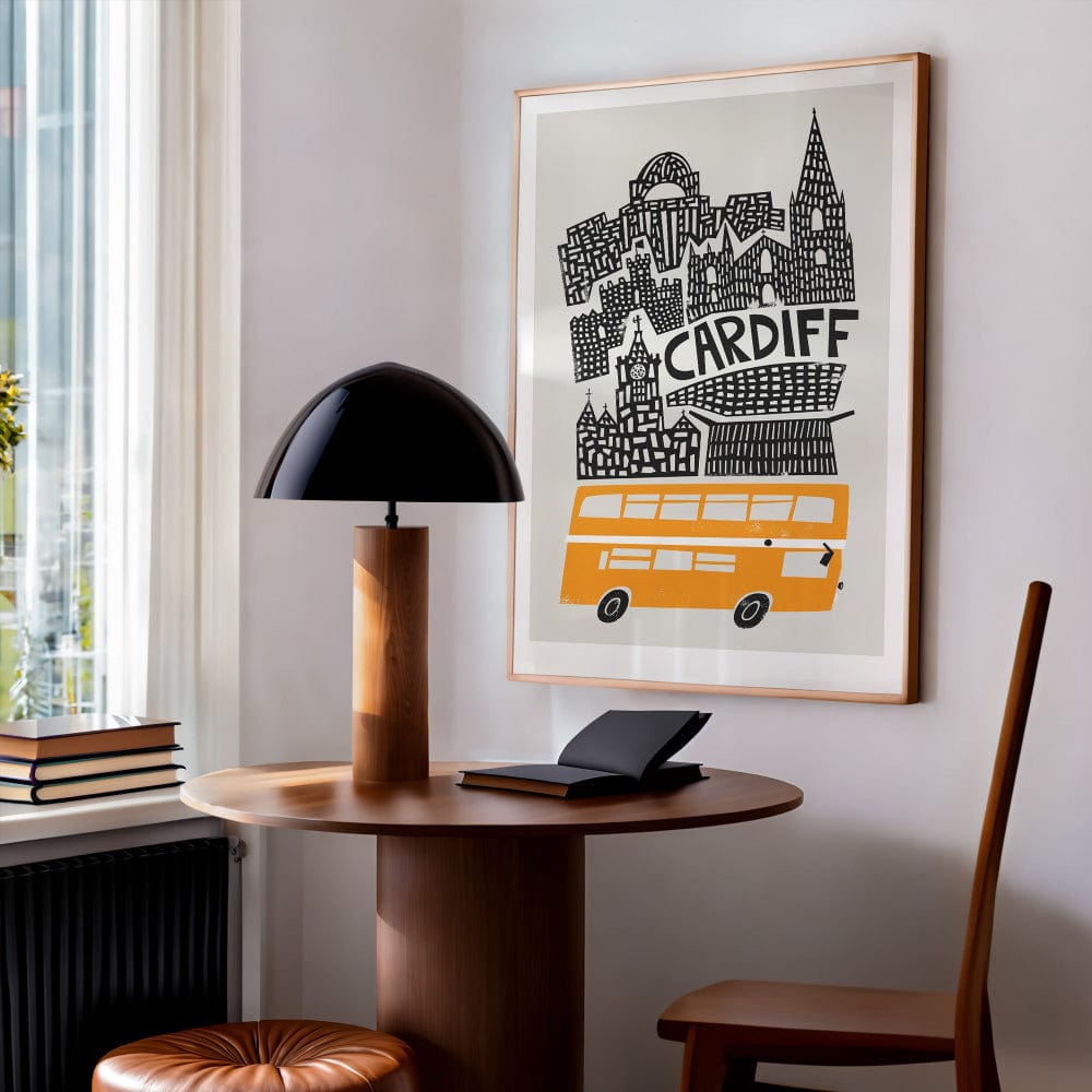 The framed Cardiff print hung above a simple wooden desk in a contemporary interior, with soft lighting and clean lines.
