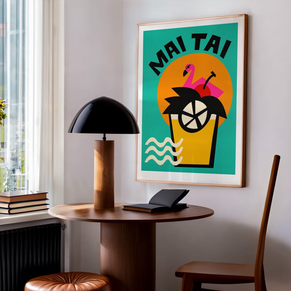 The framed Mai Tai print styled above a café table, radiating summery vibes with its turquoise background, bold shapes and retro lettering.