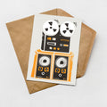 a card with a graphic design of a vintage audio equipment, including a turntable and speakers, placed on top of an envelope.