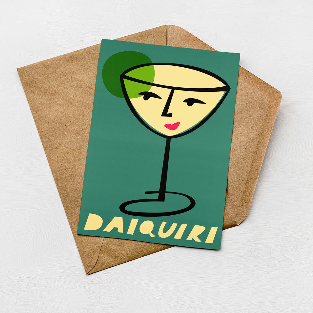 A greeting card featuring a stylized illustration of a martini glass with a face on it, placed on top of a brown envelope.