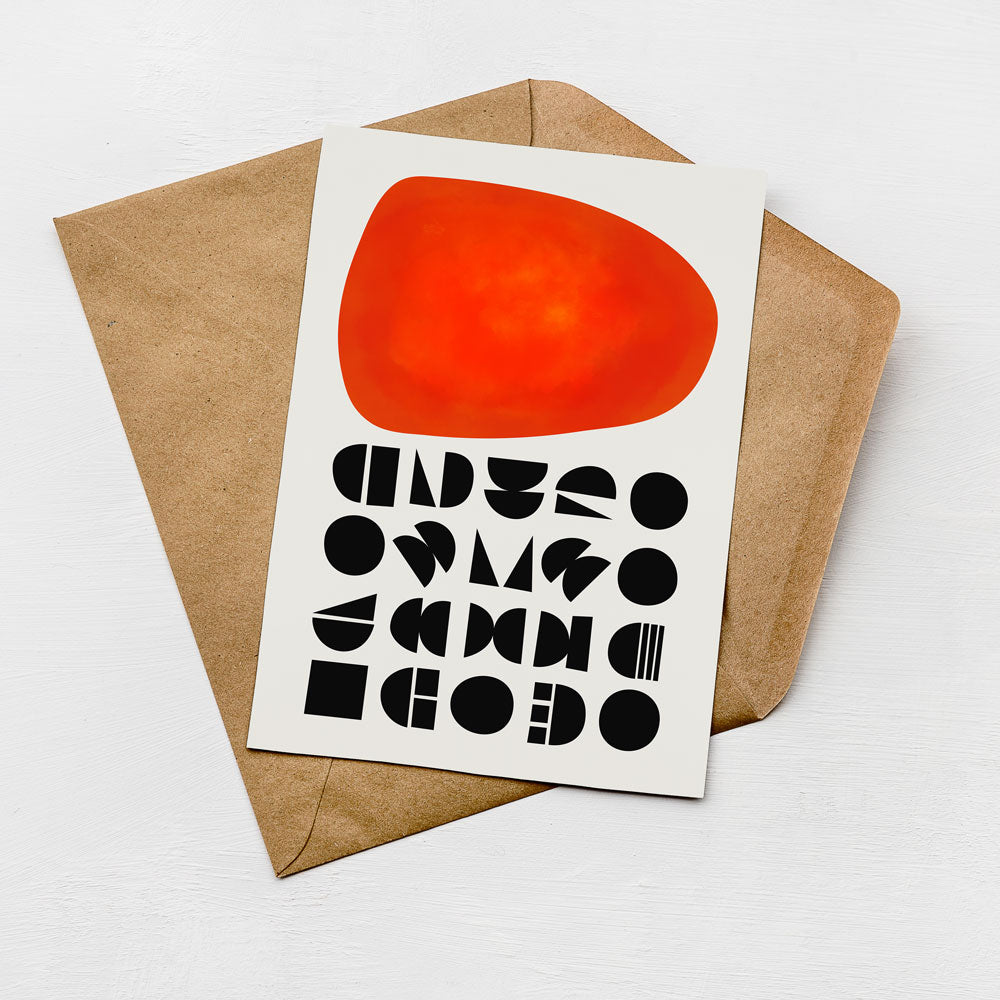 a card with a large red circle and various black geometric shapes on a white background.