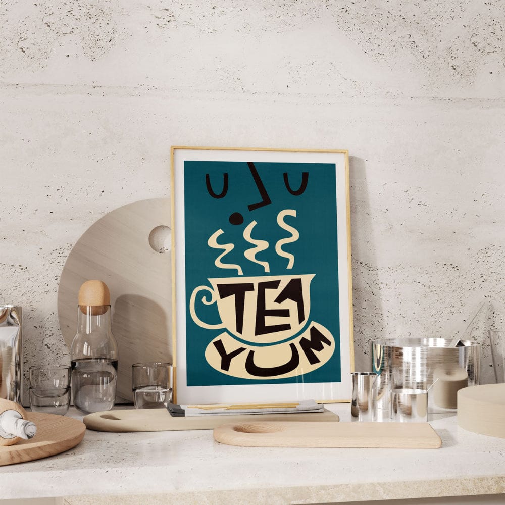 Tea-themed print propped up in a minimalist kitchen, adding warmth and a wink of humour.