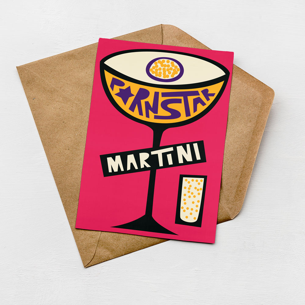 A colorful illustration of a martini glass with the word "MARTINI" written on it, placed on a brown envelope against a white background.