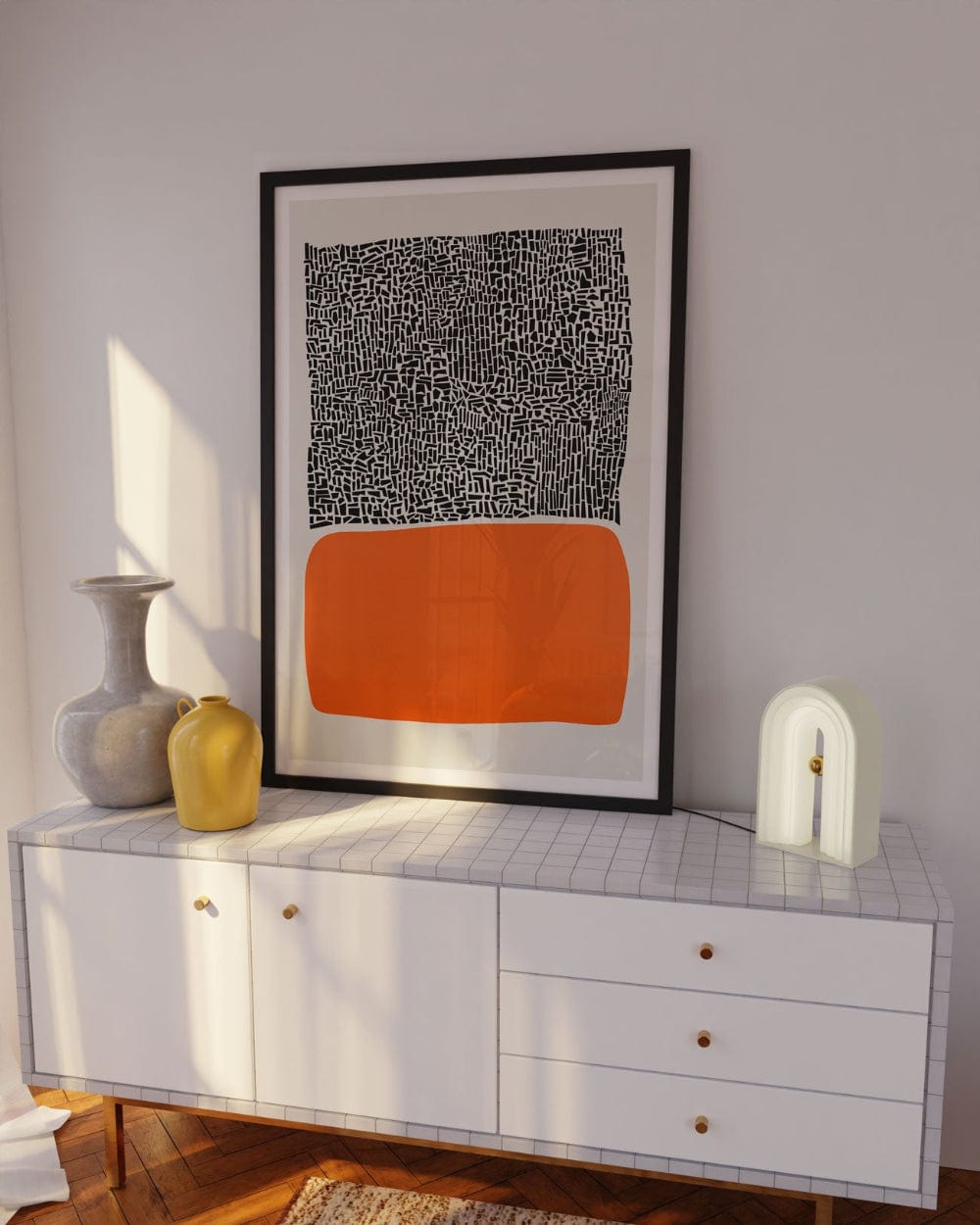 Framed abstract orange block print displayed in a stylish room with minimalist white furniture, warm lighting, and subtle sculptural decor.